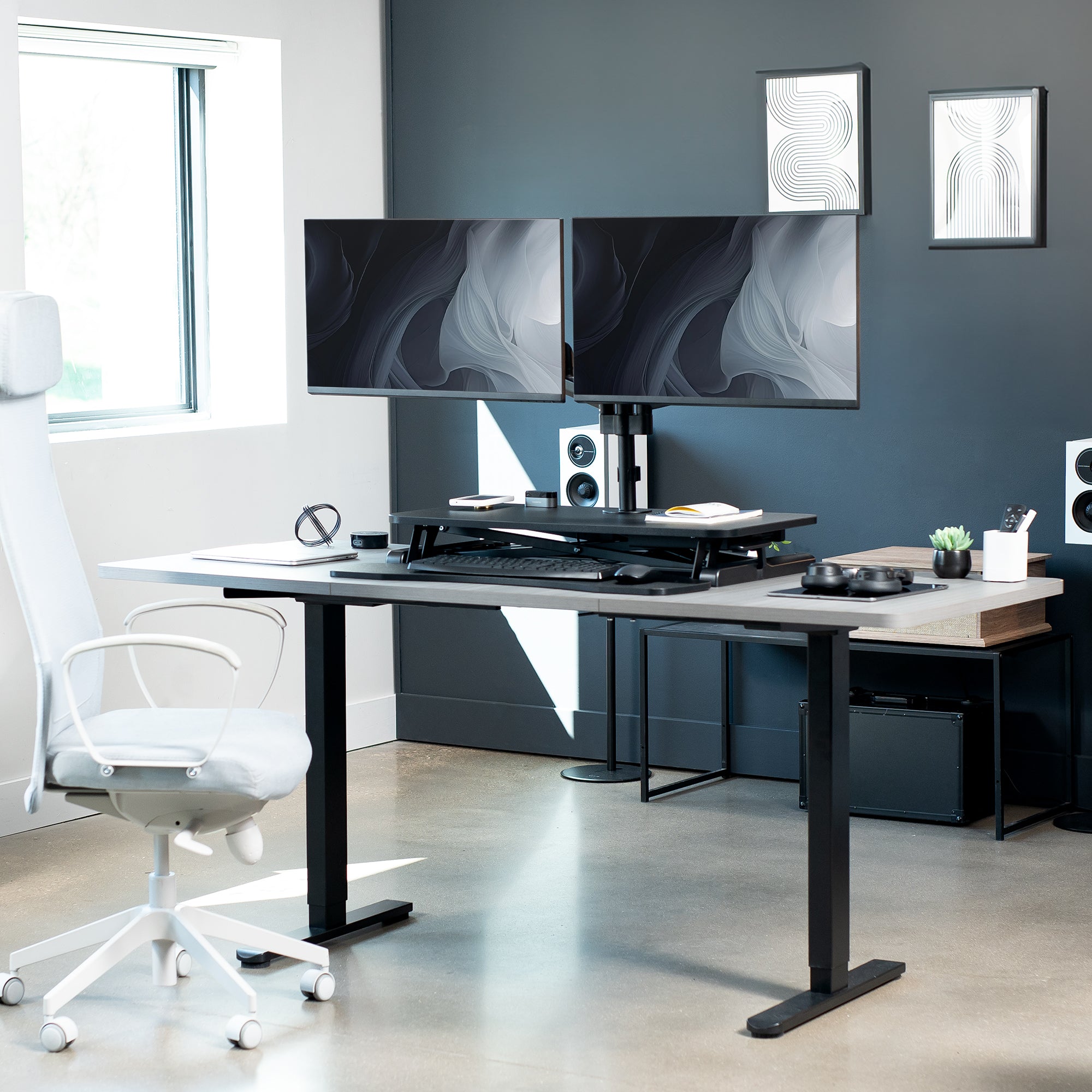 Height adjustable desk riser with articulating mechanical dual monitor mount.