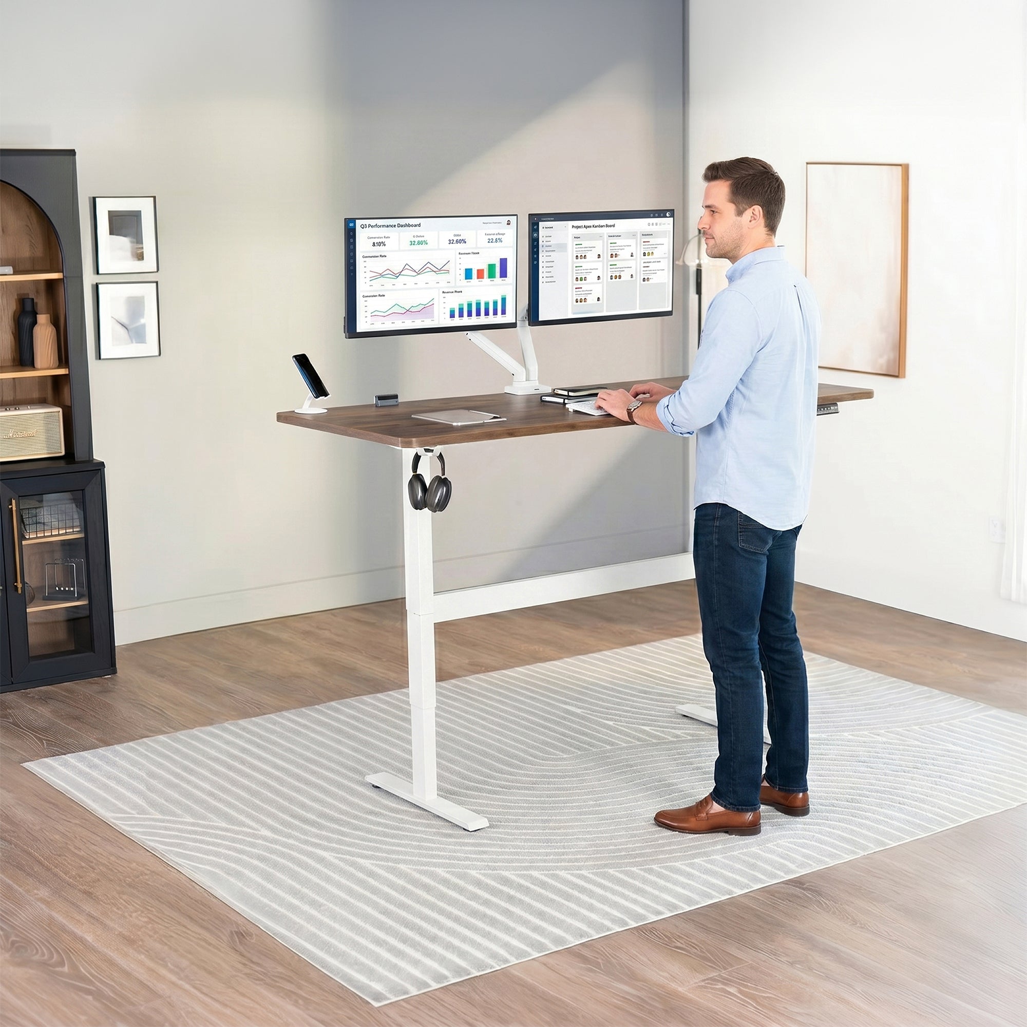 Man standing at an electric height adjustable desktop workstation in office space.