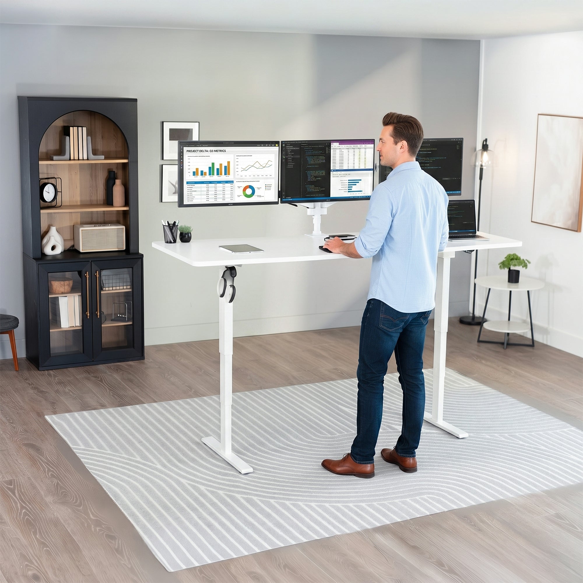 Man standing at the 2E Series - 83" x 30" Electric Desk with Touch Screen Memory Controller in office space