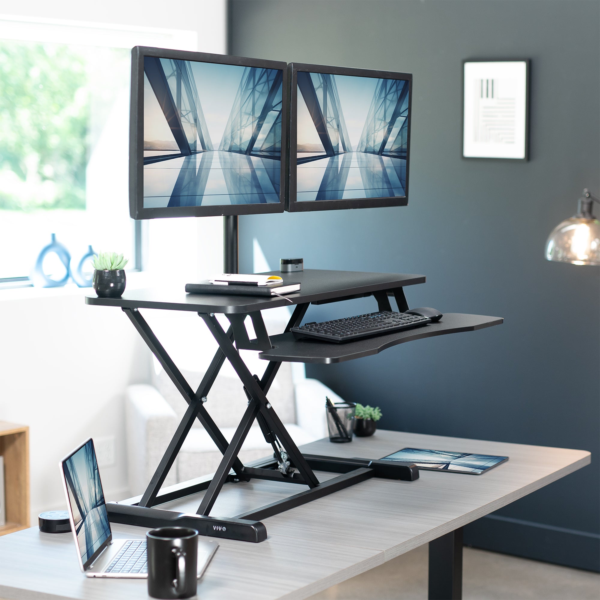 36 inch height adjustable desk riser with articulating mechanical dual monitor mount.
