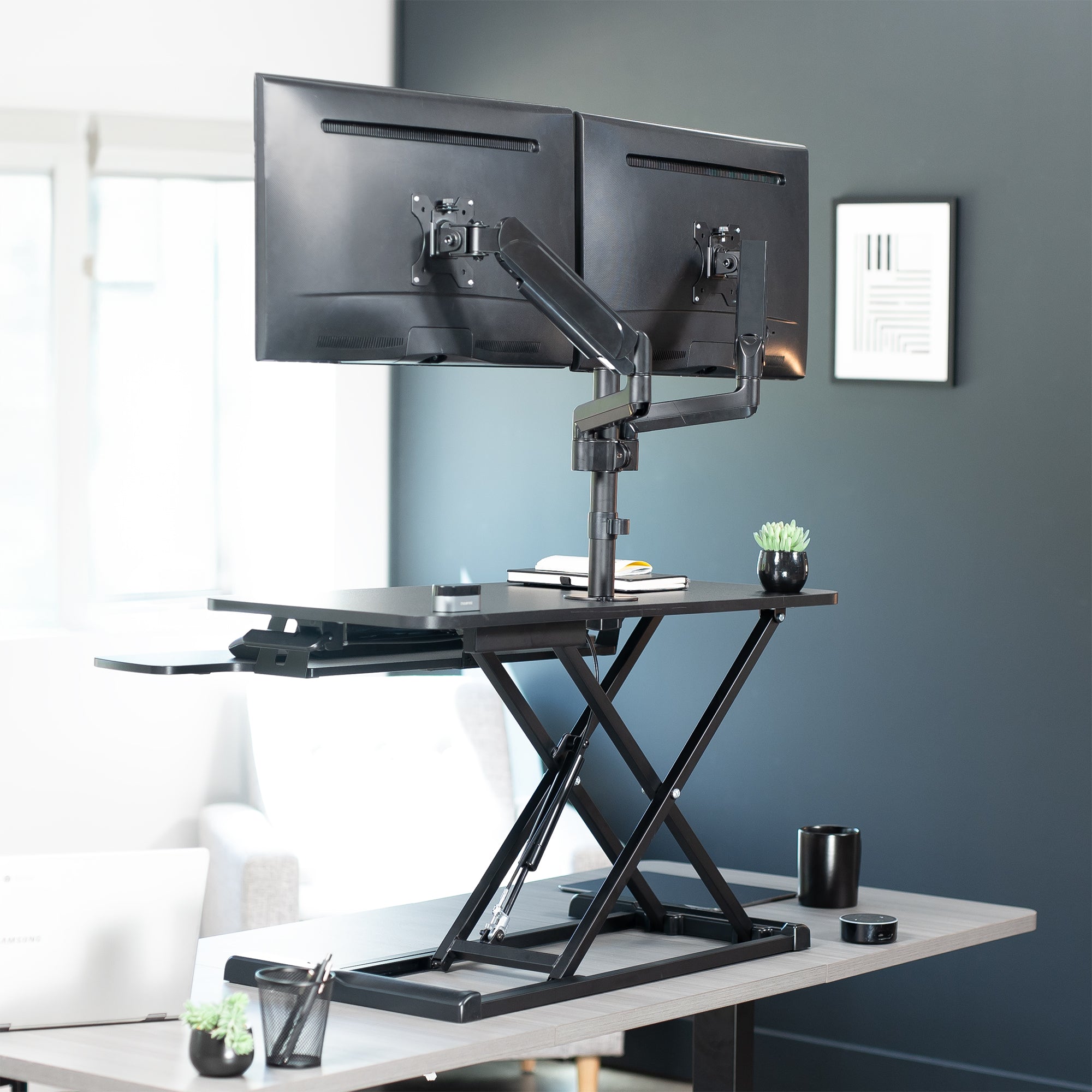 36 inch height adjustable desk riser with articulating mechanical dual monitor mount.