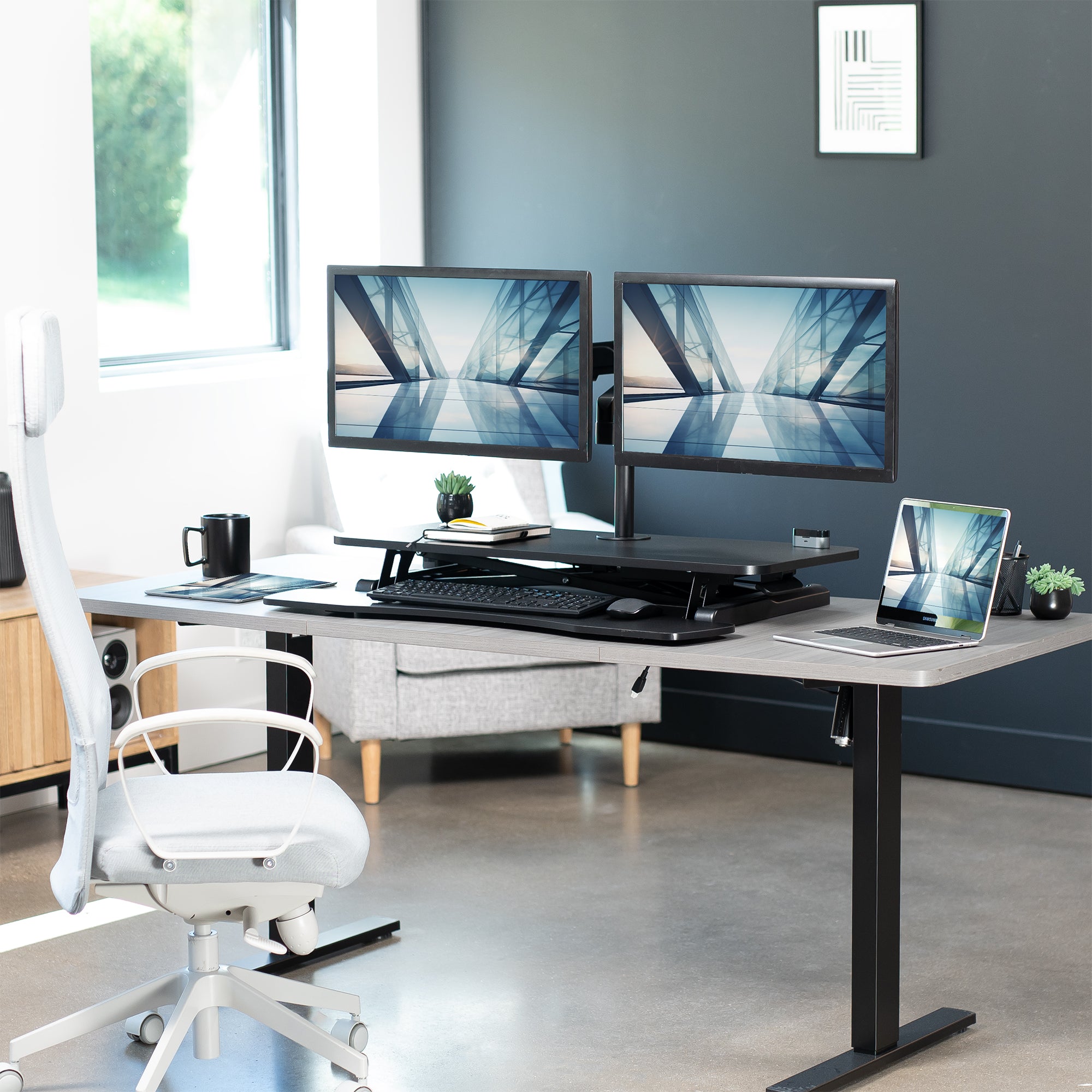 36 inch height adjustable desk riser with articulating mechanical dual monitor mount.