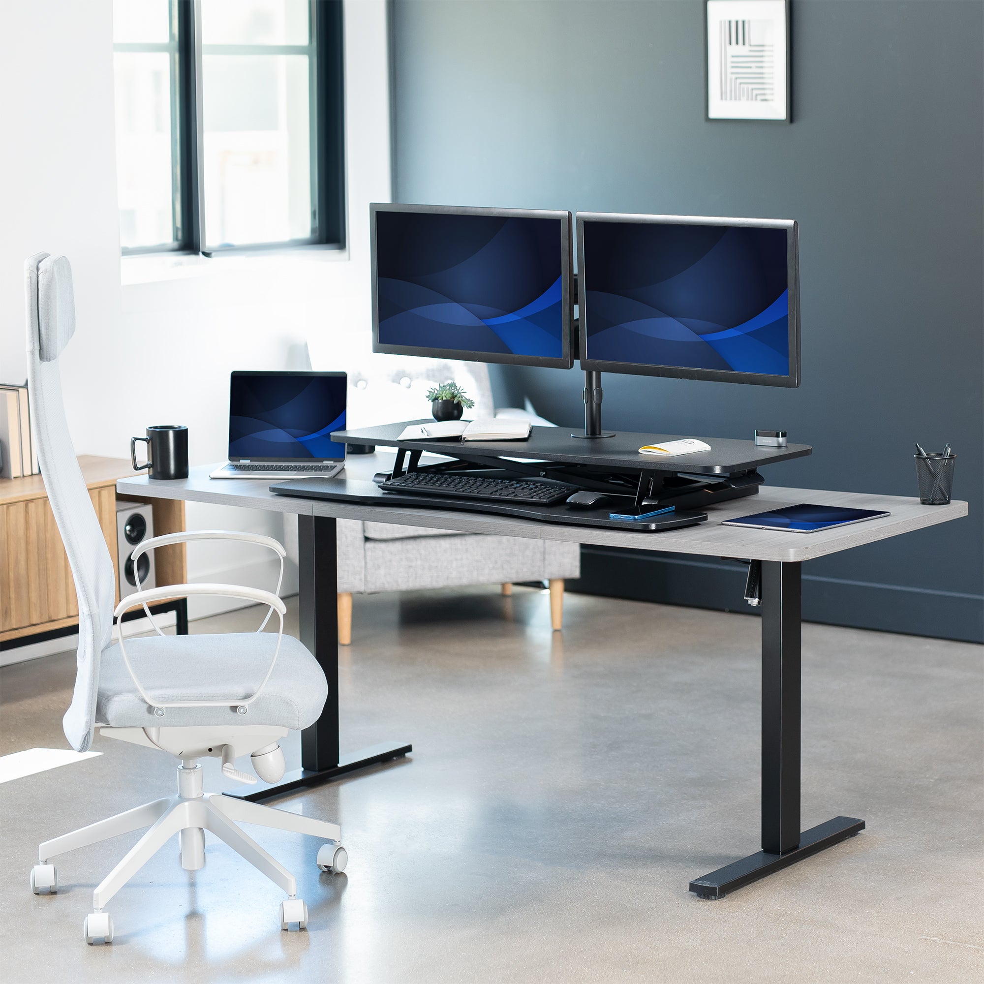 42 inch height adjustable desk riser with articulating mechanical dual monitor mount.
