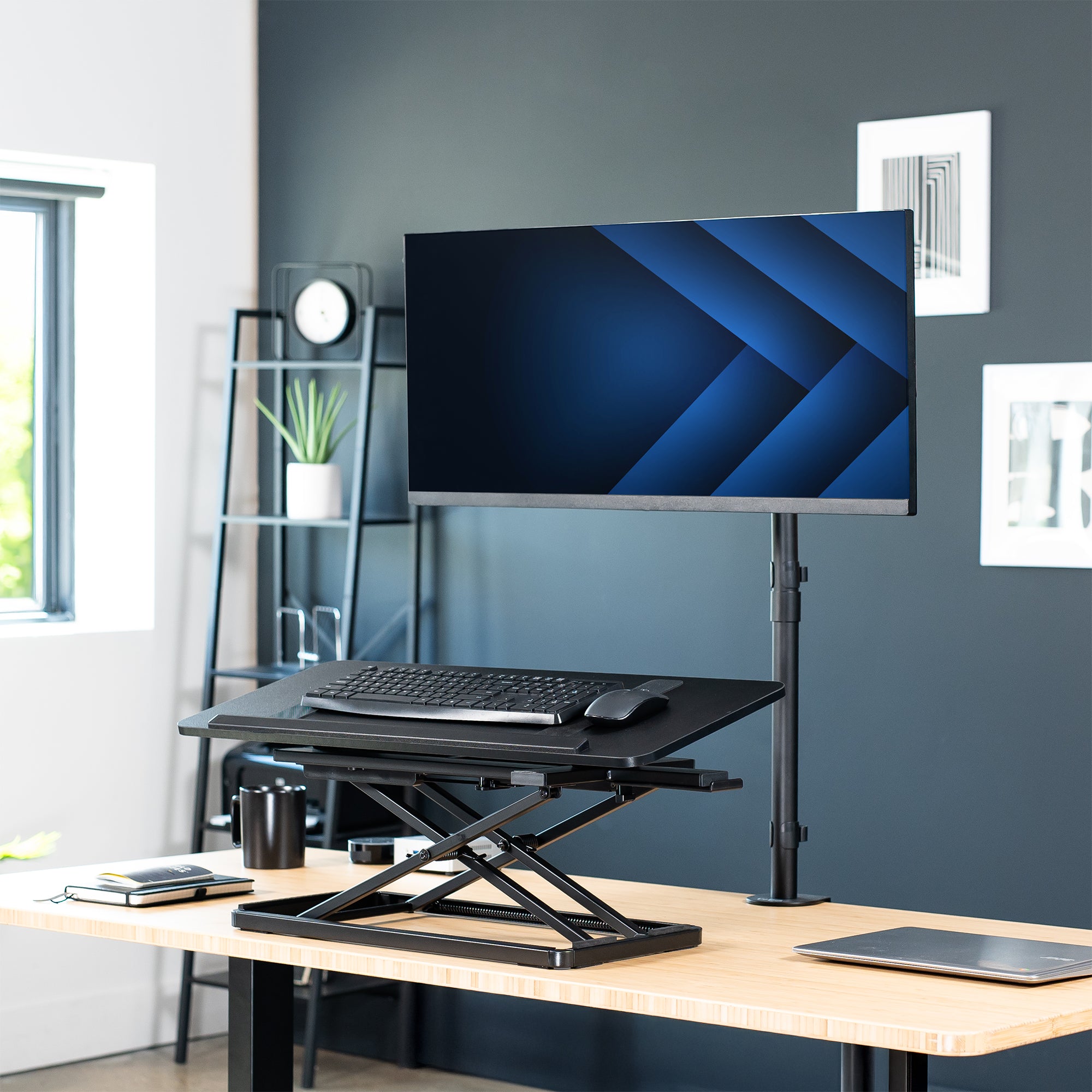 A black tilting keyboard riser with a mouse on top and the ability to adjust the angle of the keyboard surface in a modern office setting.