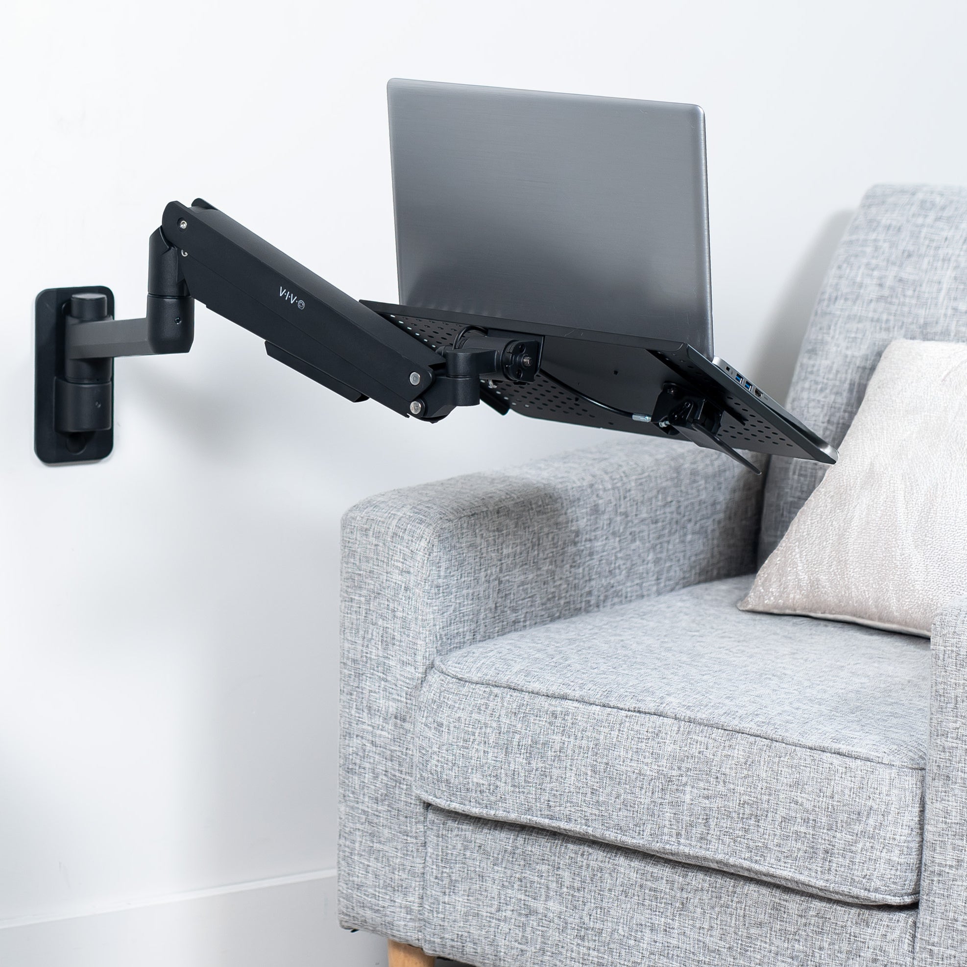 Pneumatic Wall Mounted Laptop Tray on wall creating a floating workspace.