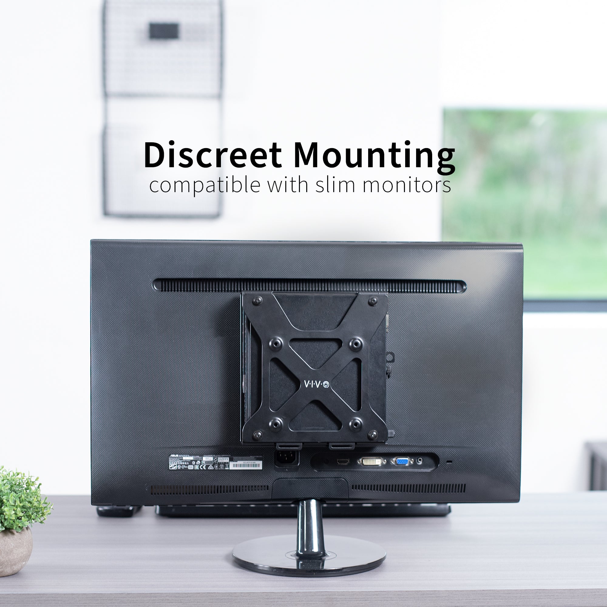 Back view of a monitor with a Mount Designed for Dell OptiPlex Micro on a desk in an office setting