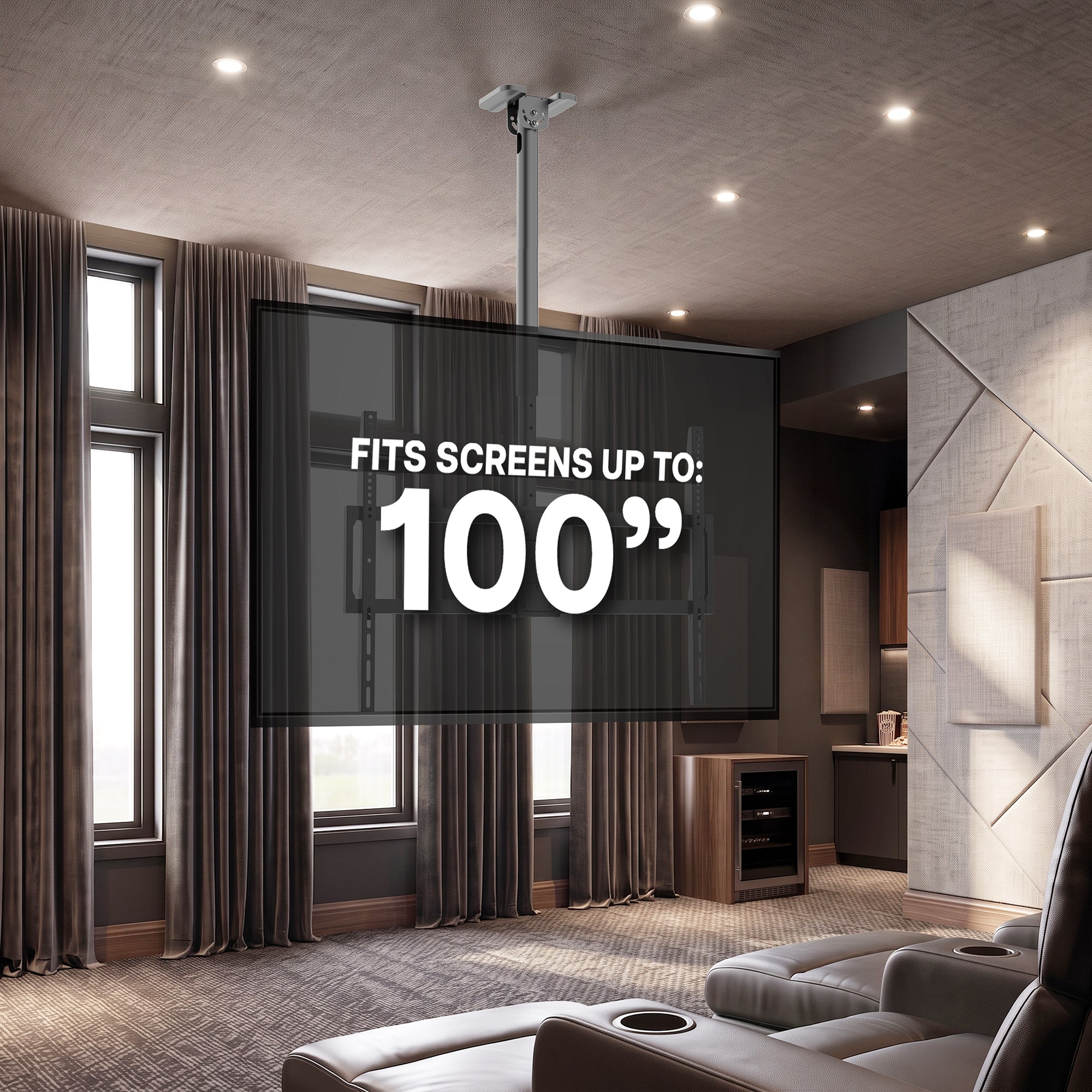 A large TV screen mounted on a ceiling in a modern home theater, with text overlay reading 'FITS SCREENS UP TO: 100"'. The room features gray leather recliners, brown curtains, and textured walls.