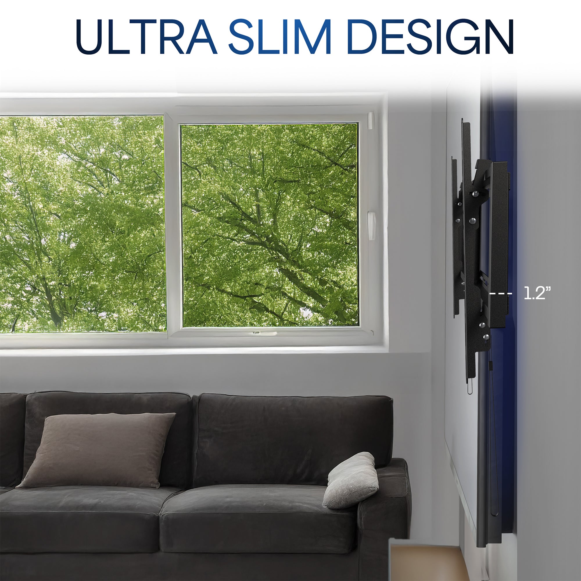 Living room with gray sofa, window showing green trees, and TV mounted on wall with text.