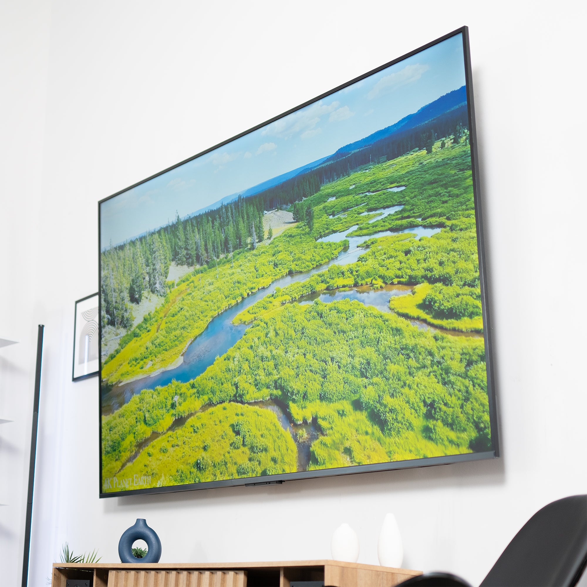 A TV tilted on a white wall with a marsh scene on the screen.