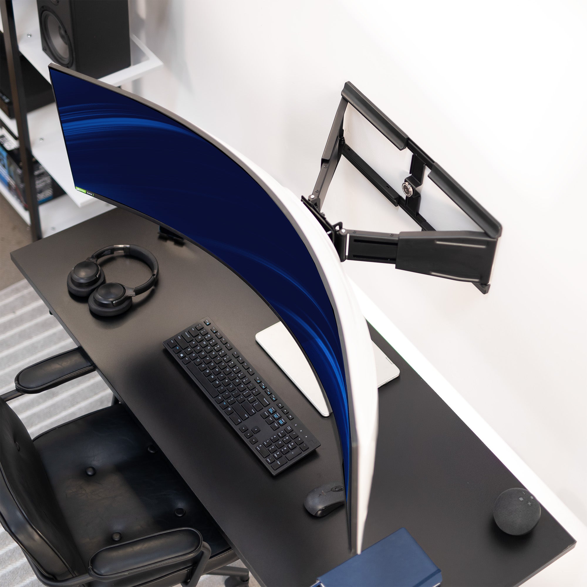 Modern office desk setup with chair, keyboard, mouse, and wall mounted ultrawide
