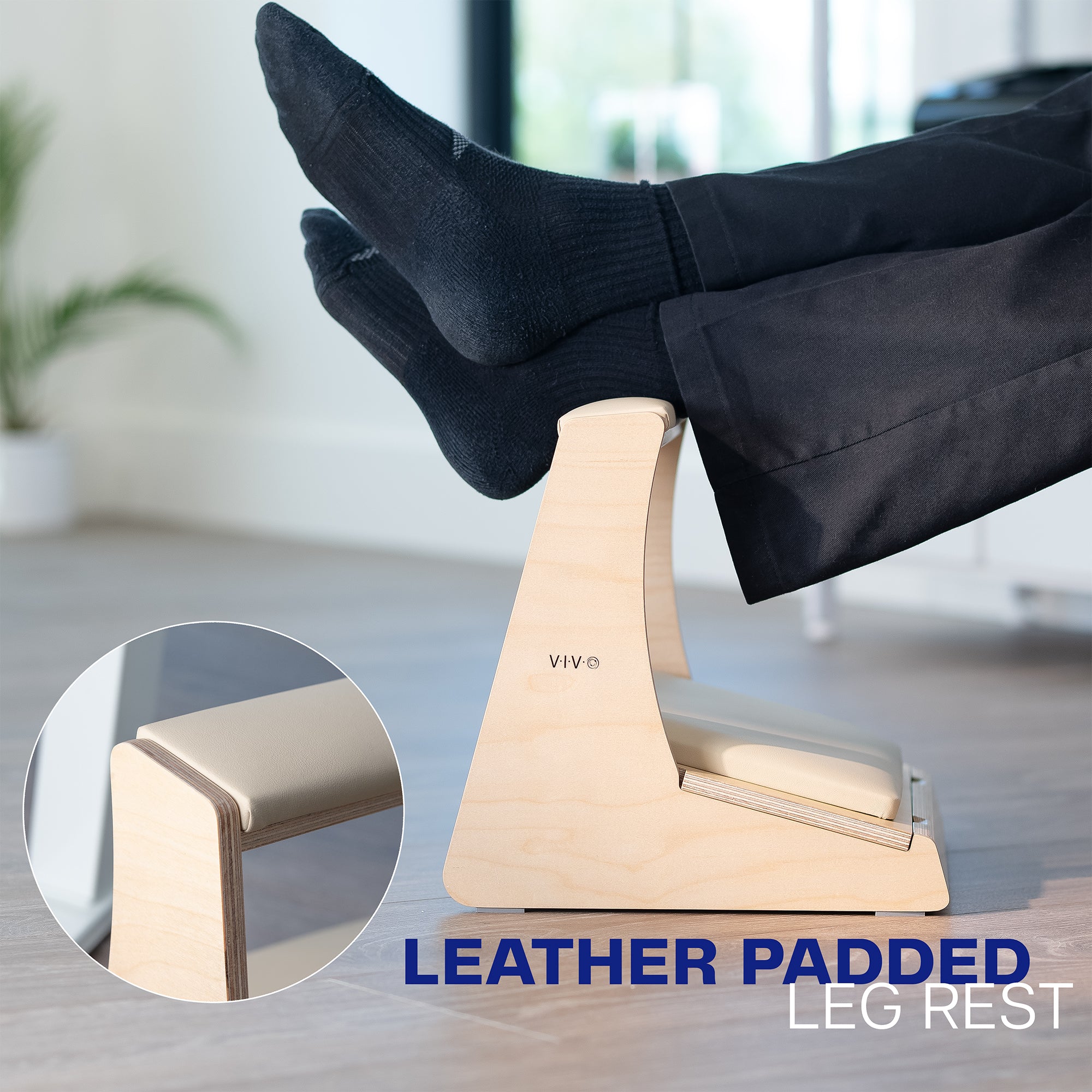 Person using a leather-padded leg rest in an office setting.