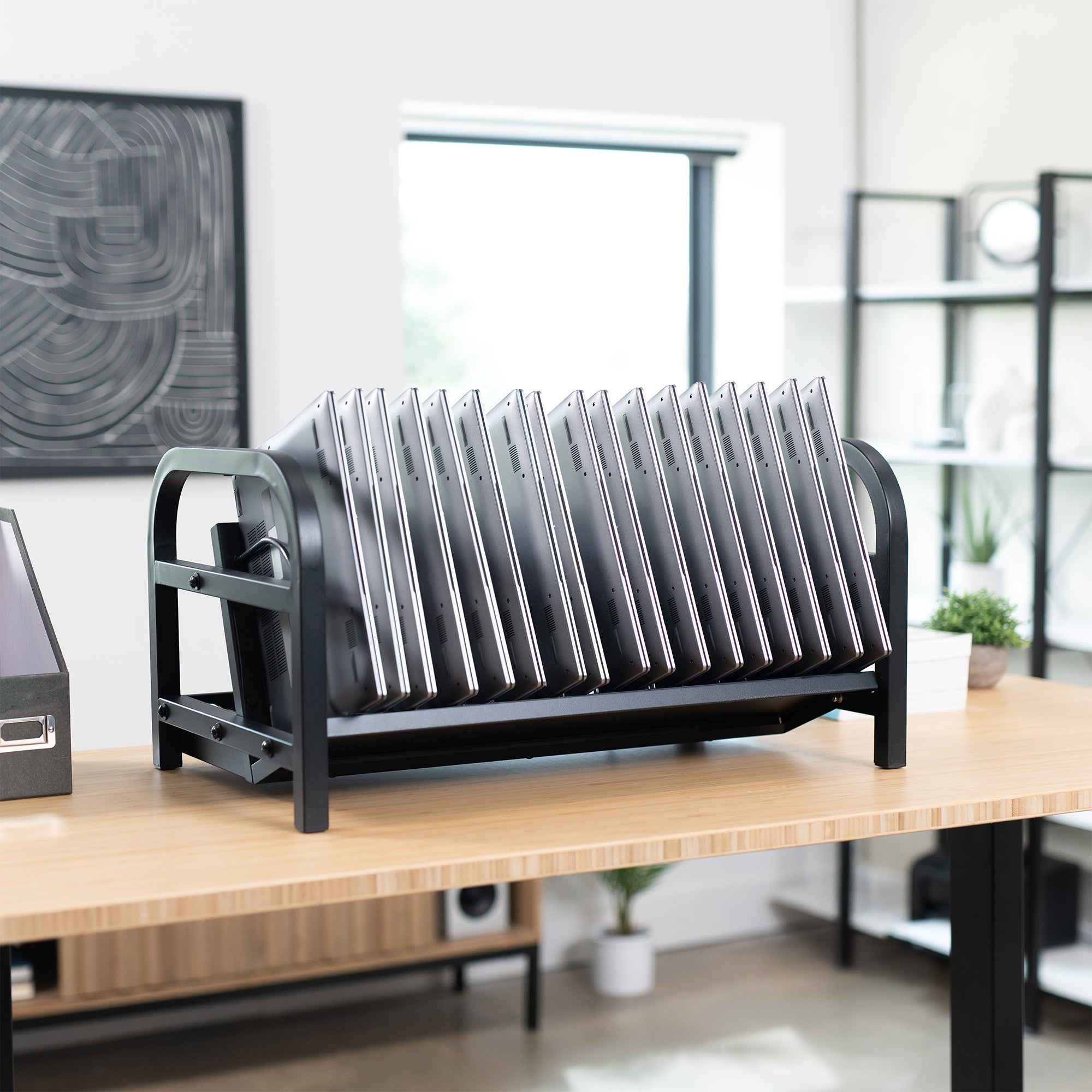 Metal device charging holder on a wooden desk in an office setting