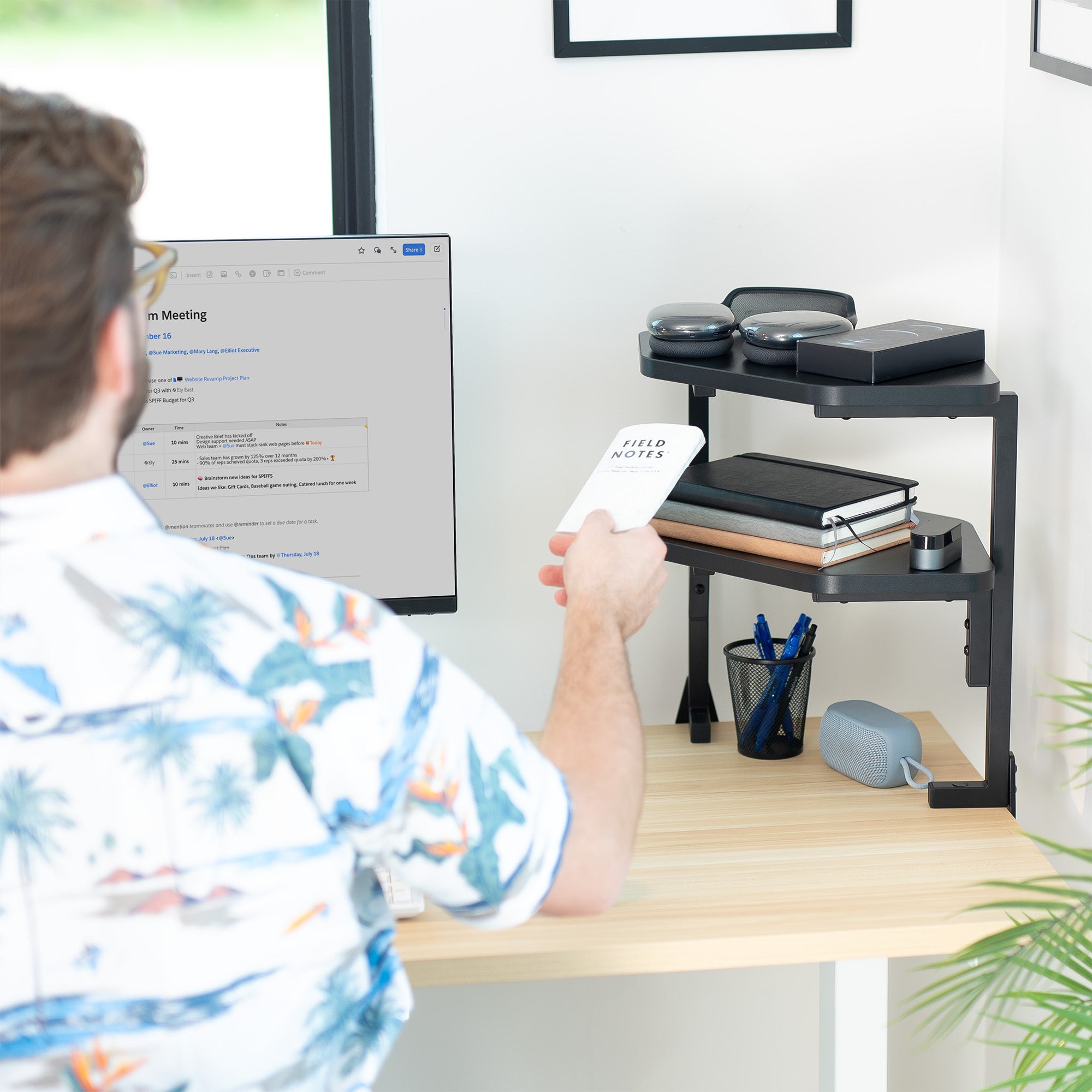 Person sitting at a desk with a computer and desk shelf
