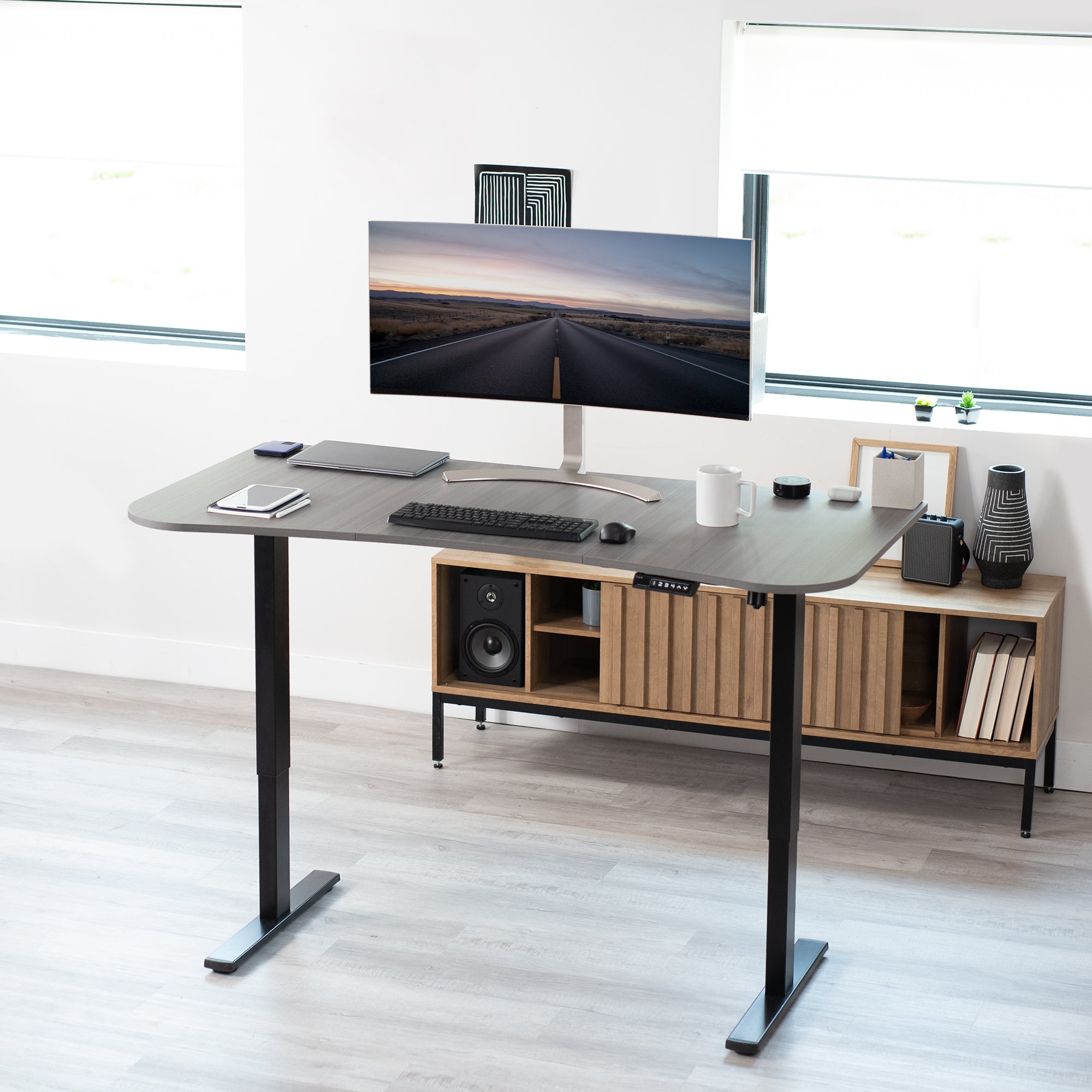 Sit to stand height adjustable electric desk with push button memory controller for ergonomic office workstation.