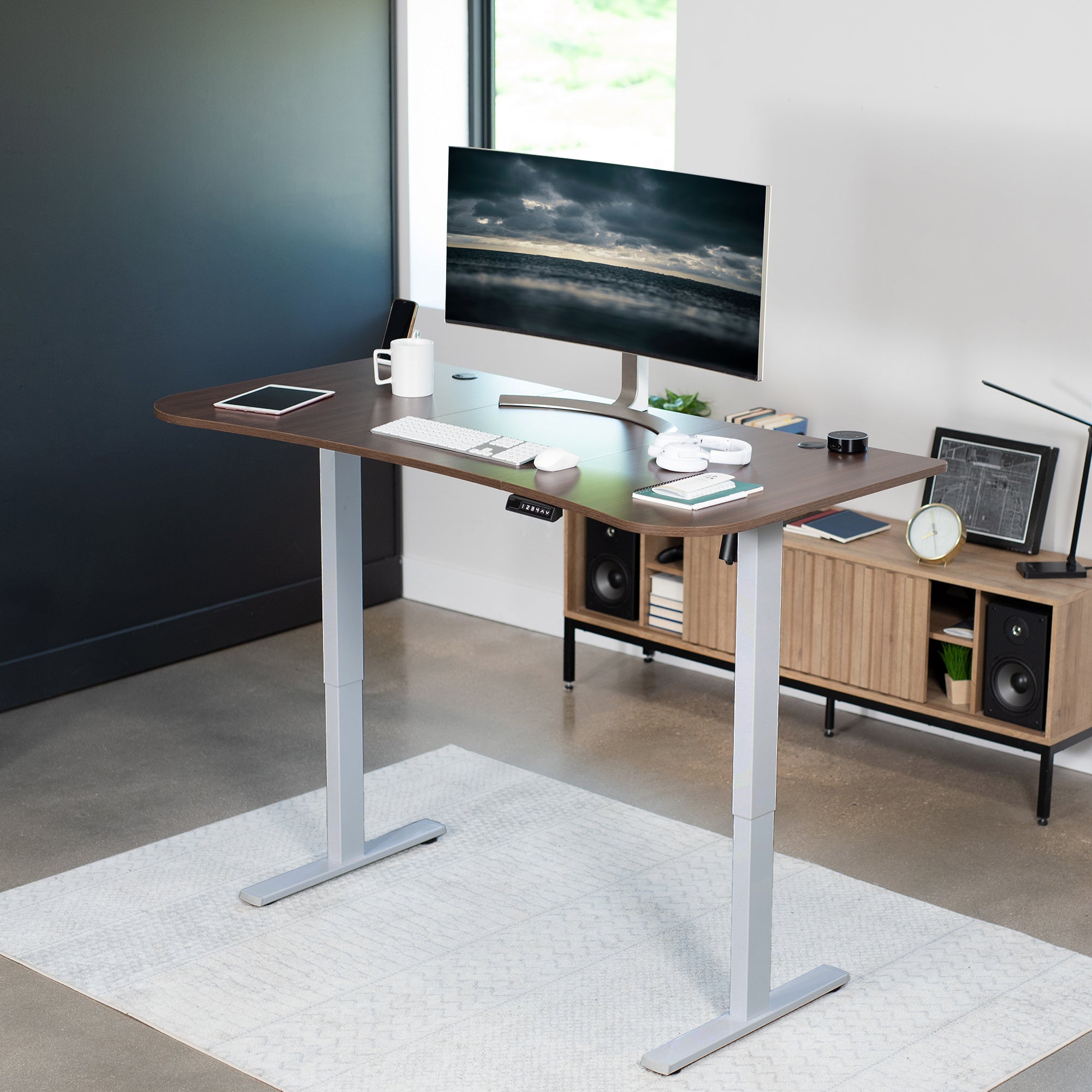 Sit to stand height adjustable electric desk with push button memory controller for ergonomic office workstation.