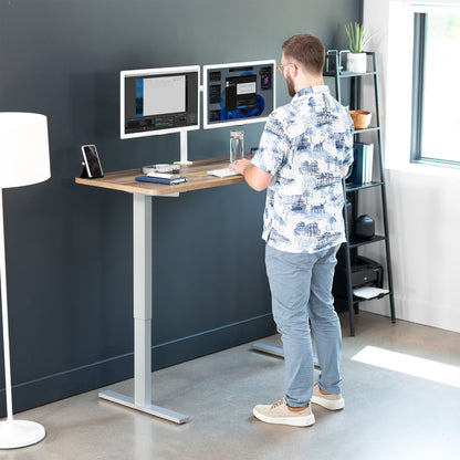 Sturdy wood plank pattern ergonomic sit or stand active desk workstation with adjustable height using smart control panel.