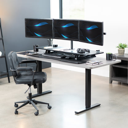 Spacious height adjustable desk riser with articulating triple monitor mount.