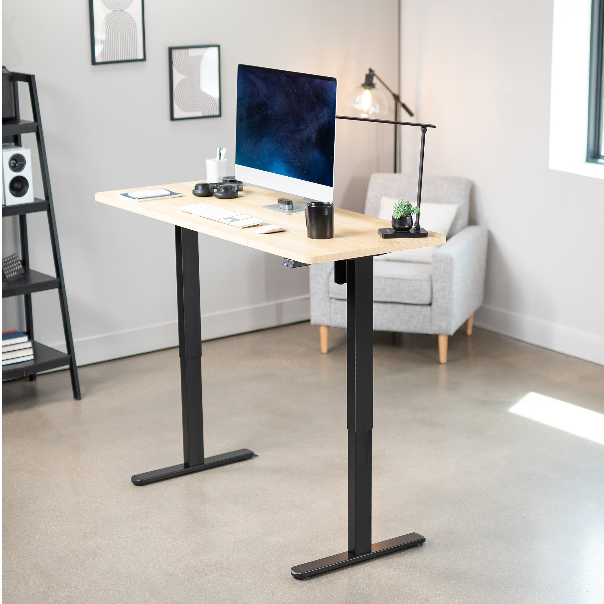 Modern office setup with a standing desk, computer monitor, and chair.