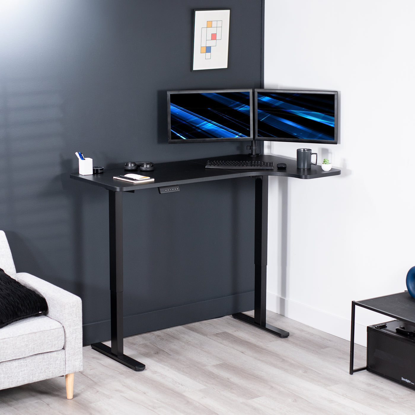 Dual monitor mount attached to a height adjustable desk with a slight corner curve offering more workspace to the side of choice.