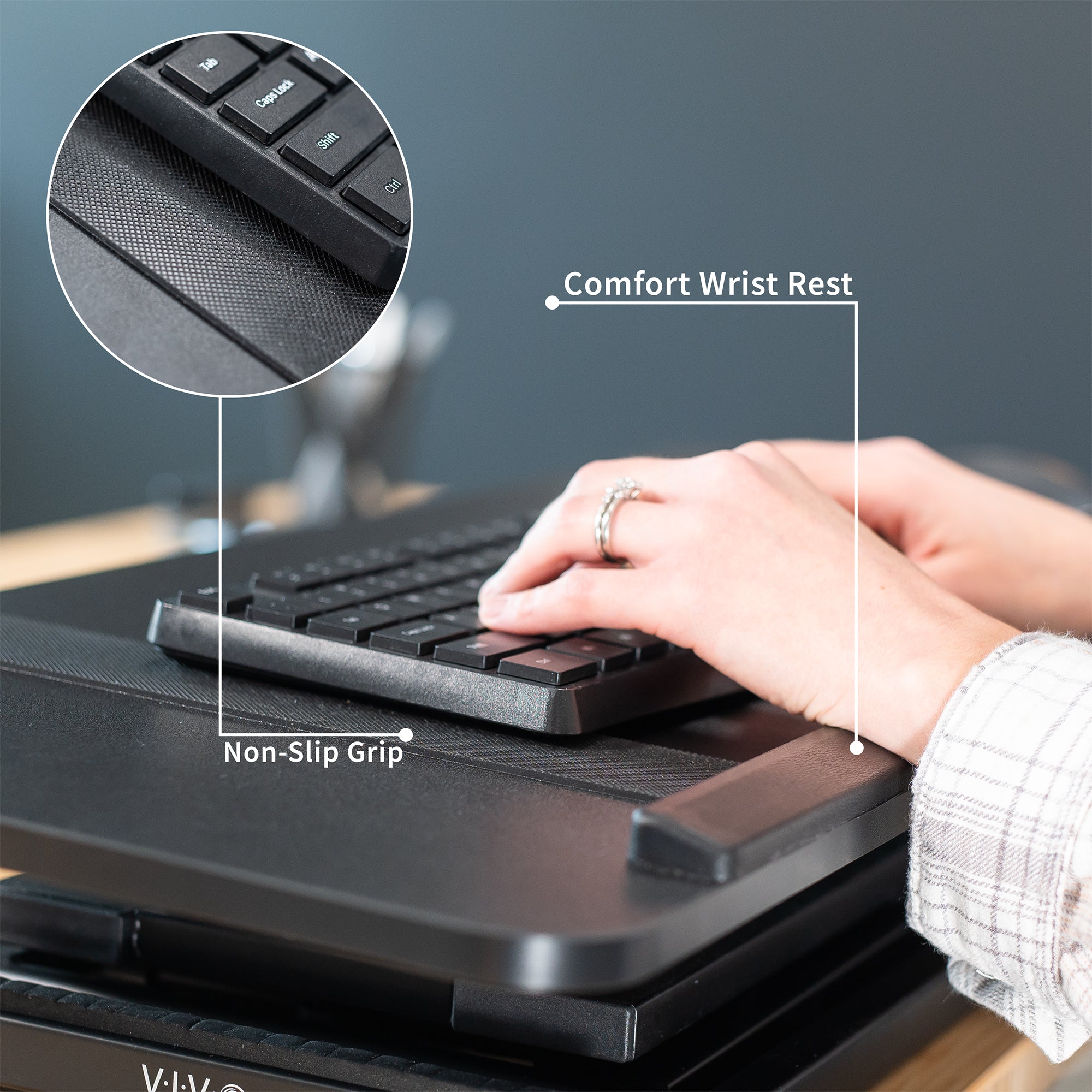 A black tilting keyboard riser with a wrist pad and non-slip grip for keyboard. 