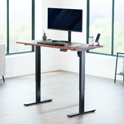 Adjustable height desk with computer setup in a bright room