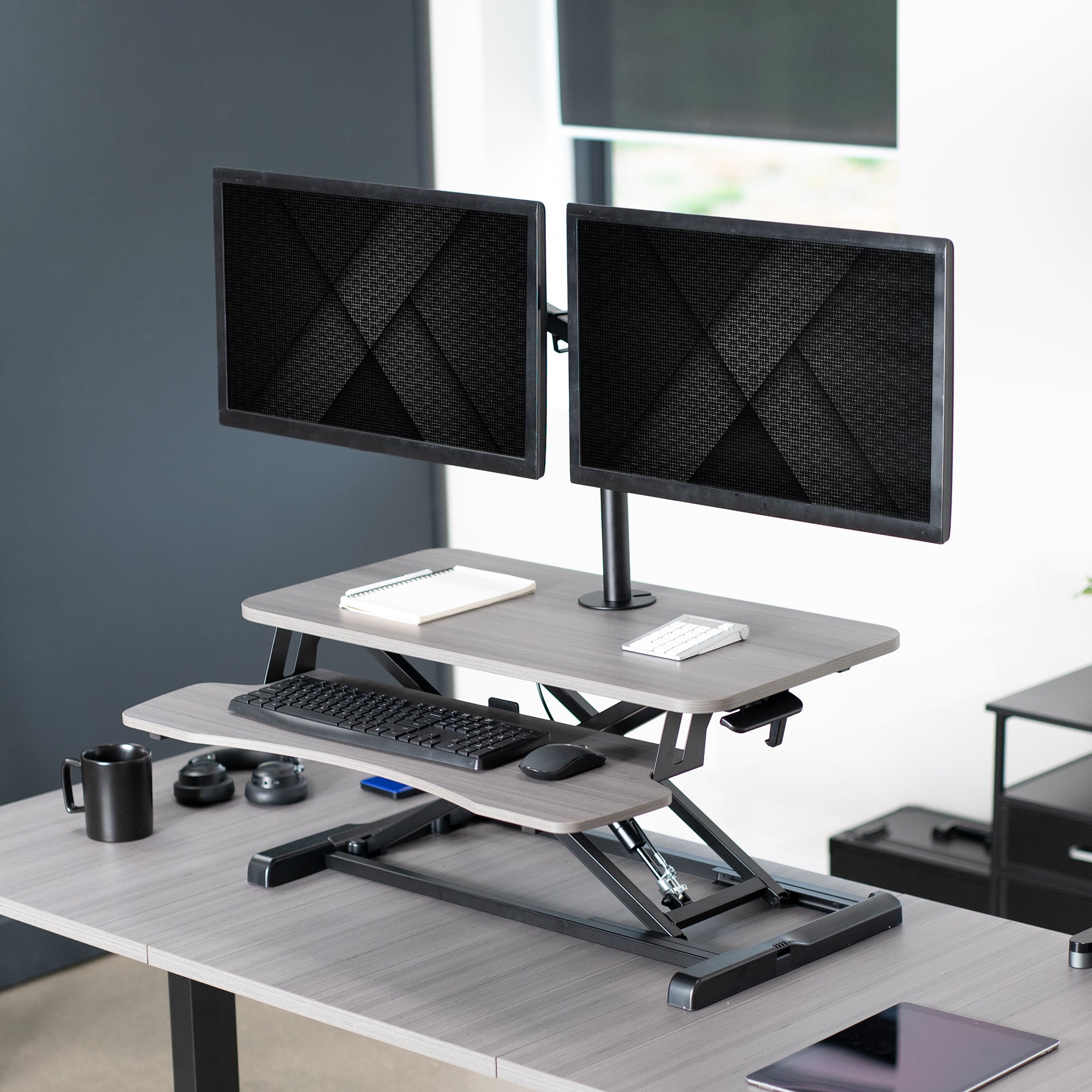 Sturdy height adjustable desk converter with articulating dual monitor mount.