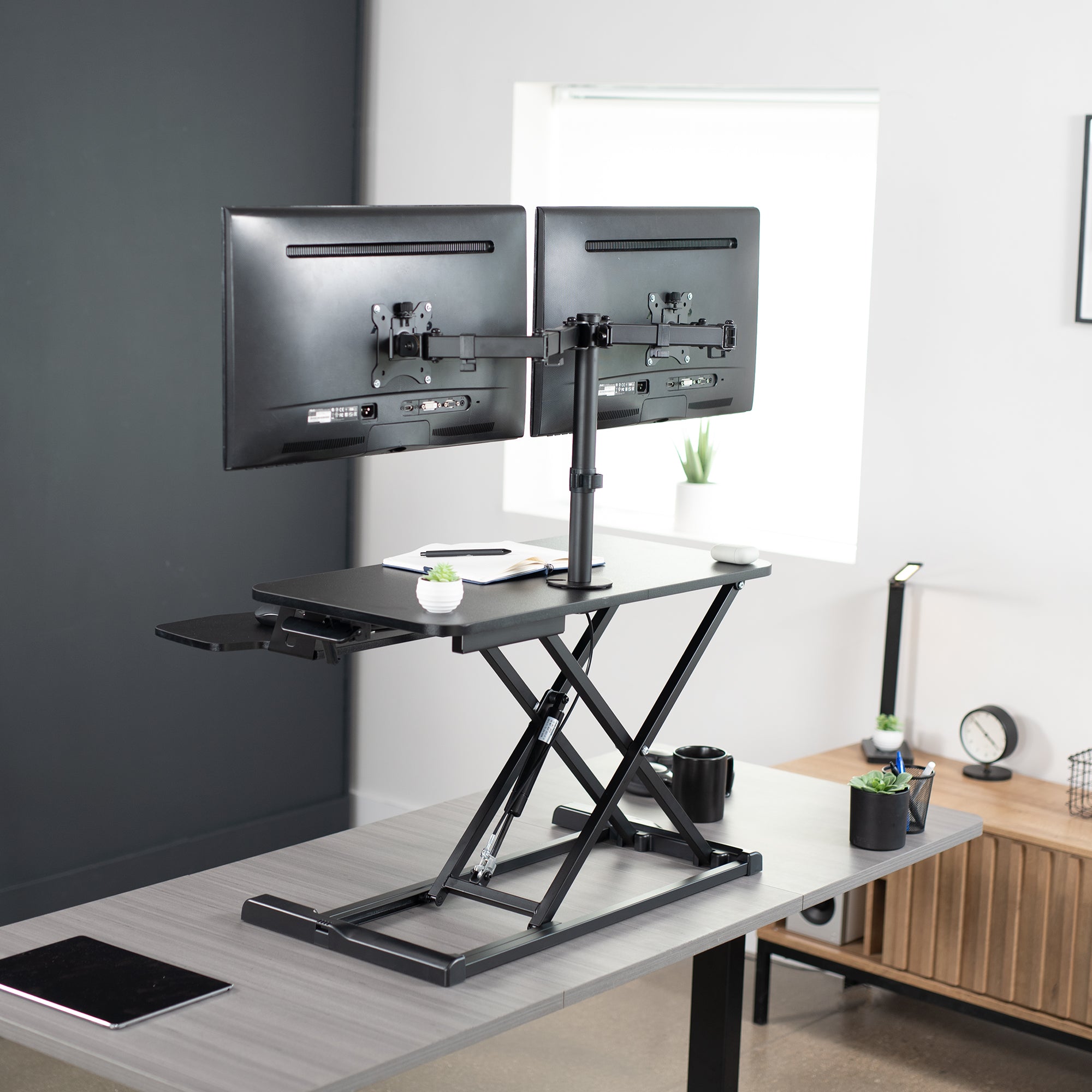 Sturdy height adjustable desk converter with articulating dual monitor mount.