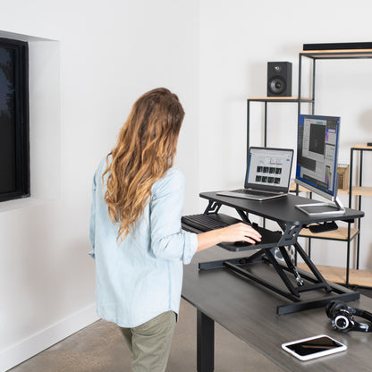 Heavy-duty height adjustable desk converter monitor riser with 2 tiers.