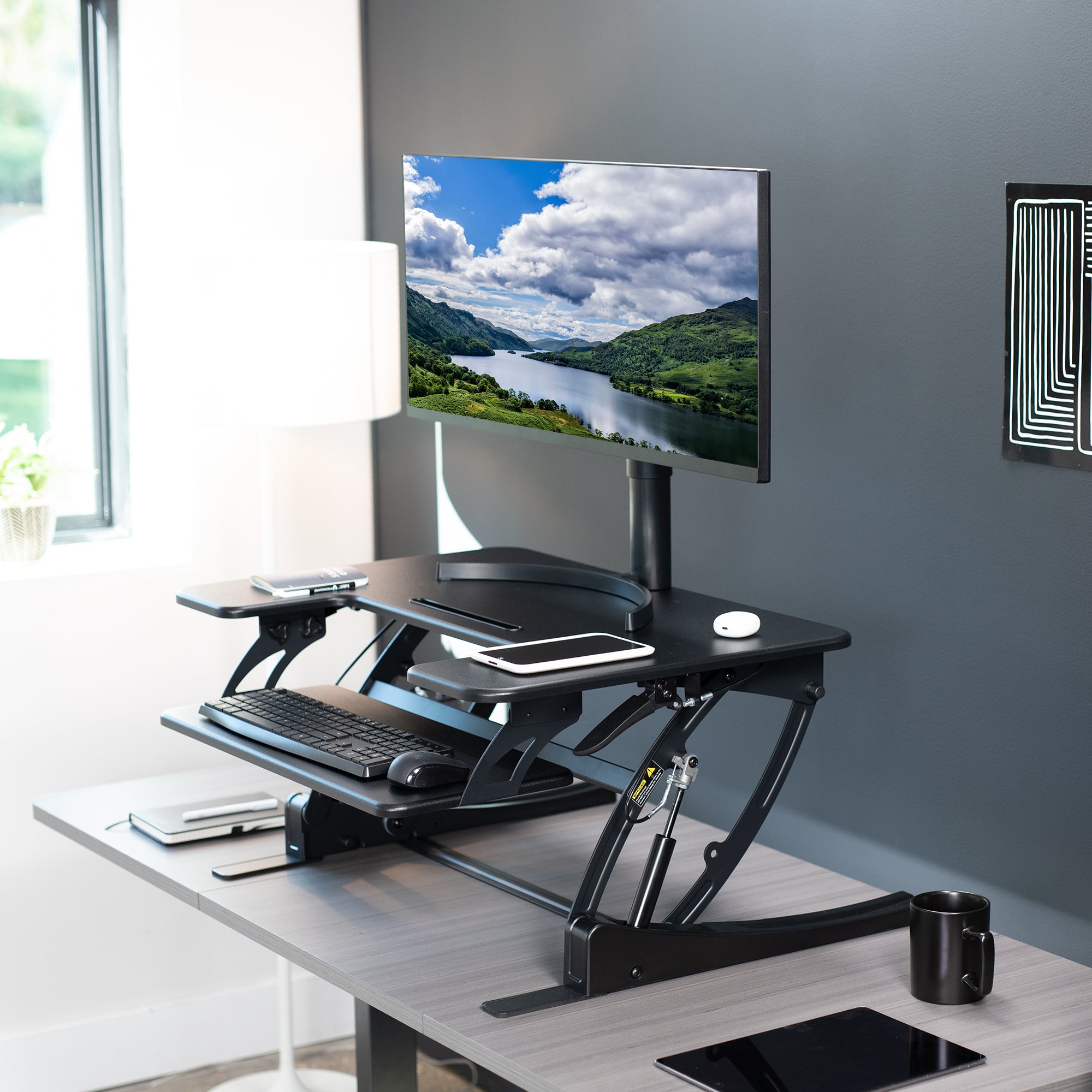 Heavy-duty height adjustable desk converter monitor riser with two tiers.