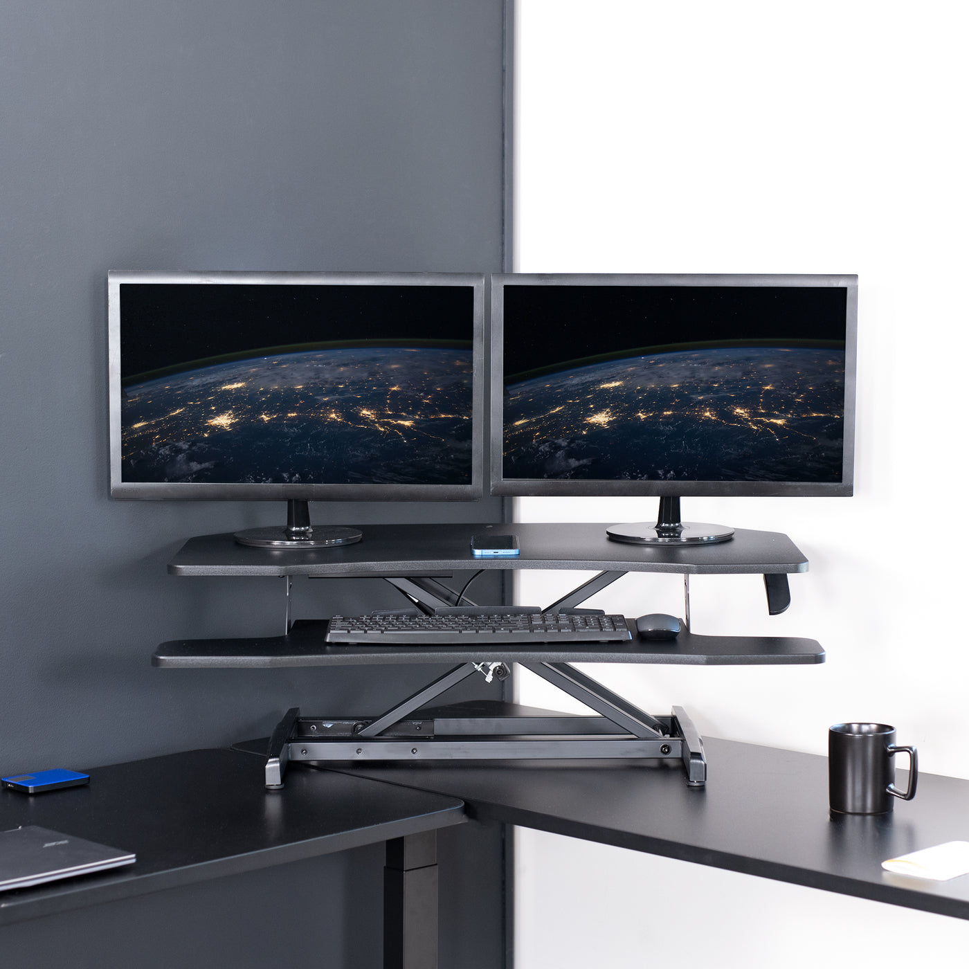 Heavy-duty height adjustable desk converter monitor riser for corner desk workstation.