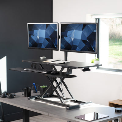Sturdy height adjustable desk converter with articulating dual monitor mount.