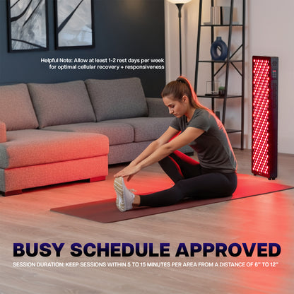 Woman stretching on a mat in a living room with a red light therapy device.
