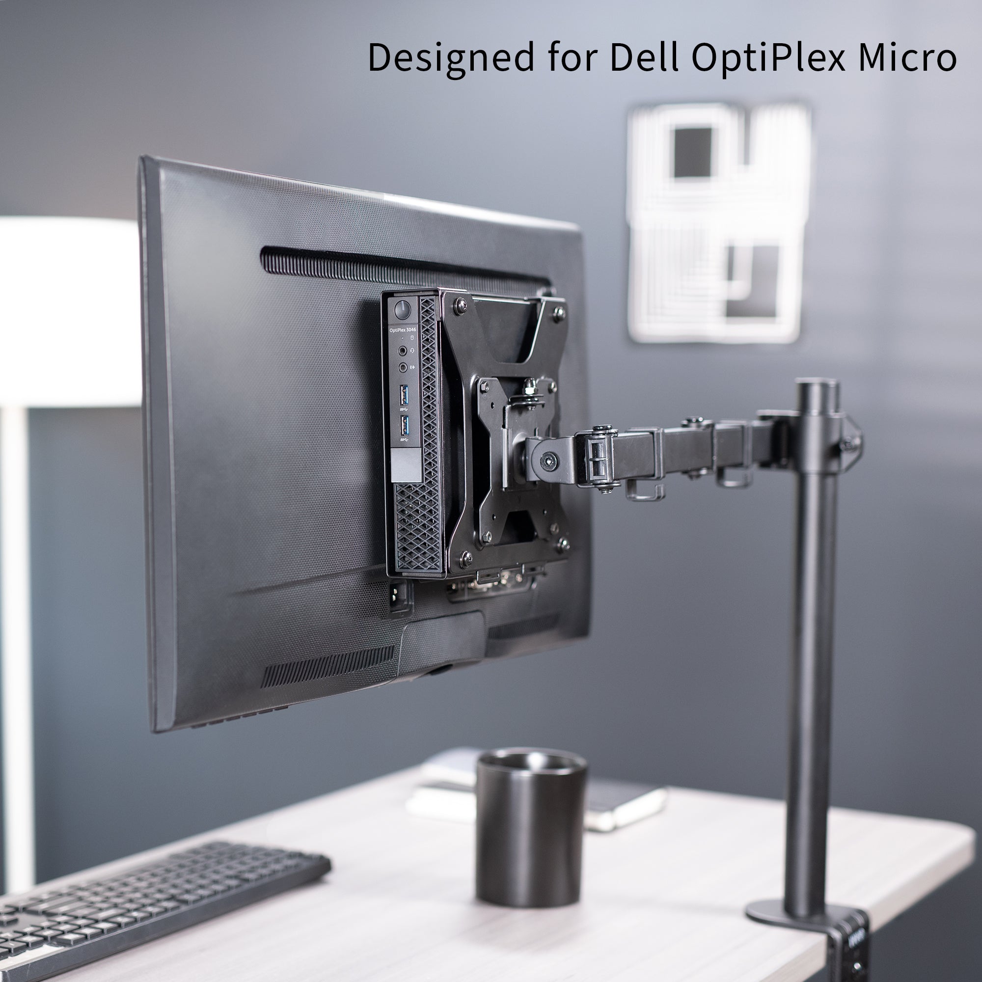 Mount Designed for Dell OptiPlex Micro mounted on single monitor mount on a desk with text 'Designed for Dell OptiPlex Micro' on a gray background