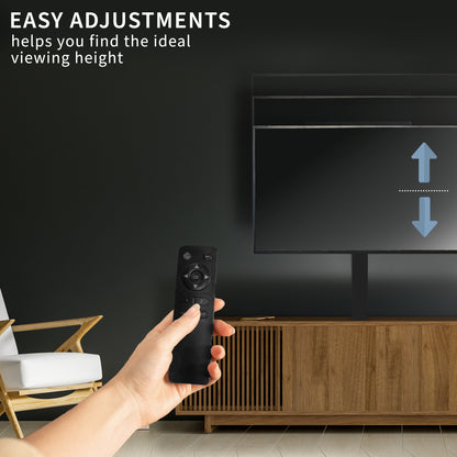 Hand holding a remote control adjusting a TV with text on a dark wall.