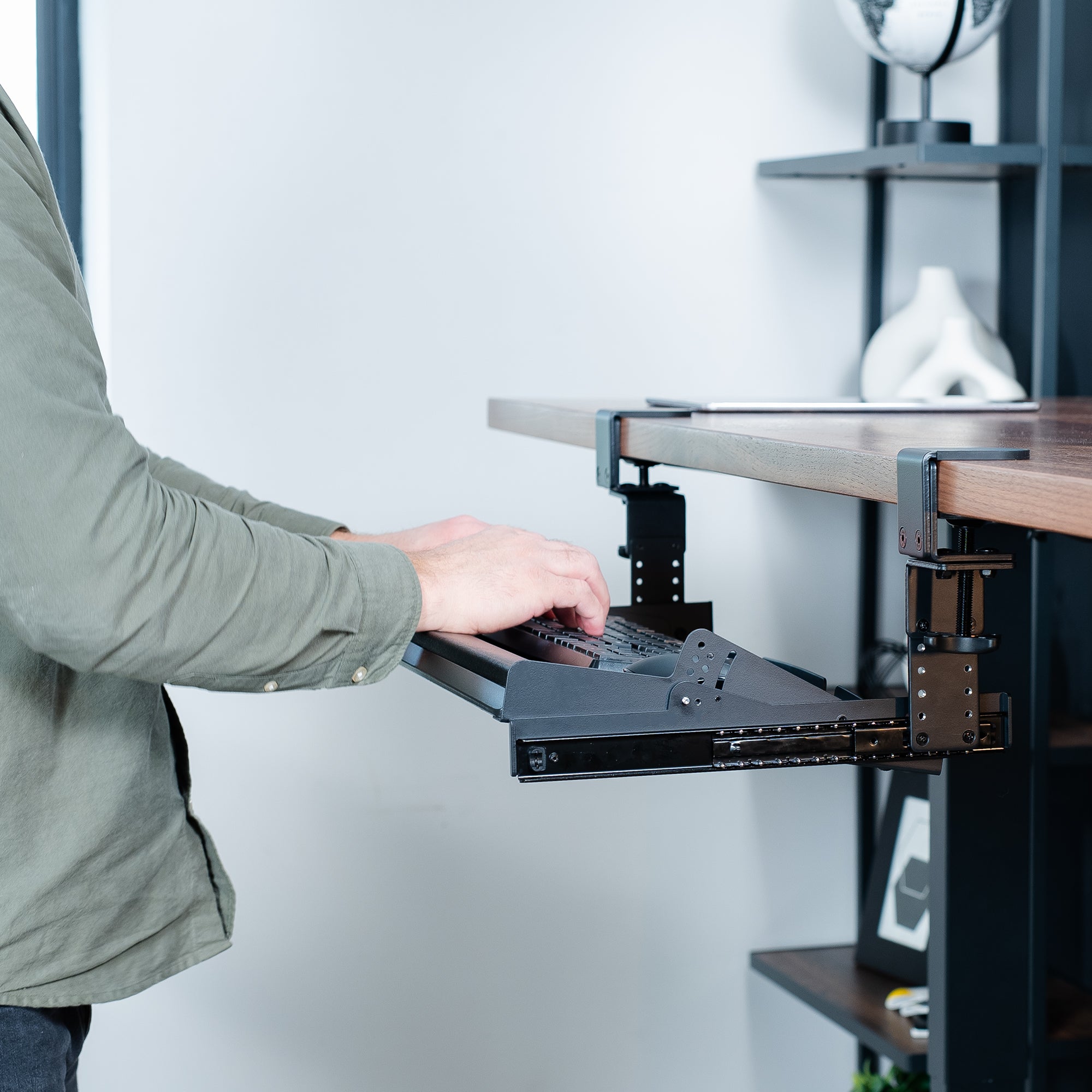 Modern pull-out clamp-on height adjustable tilting keyboard tray. Clamps can swivel to accommodate corner desk setups.