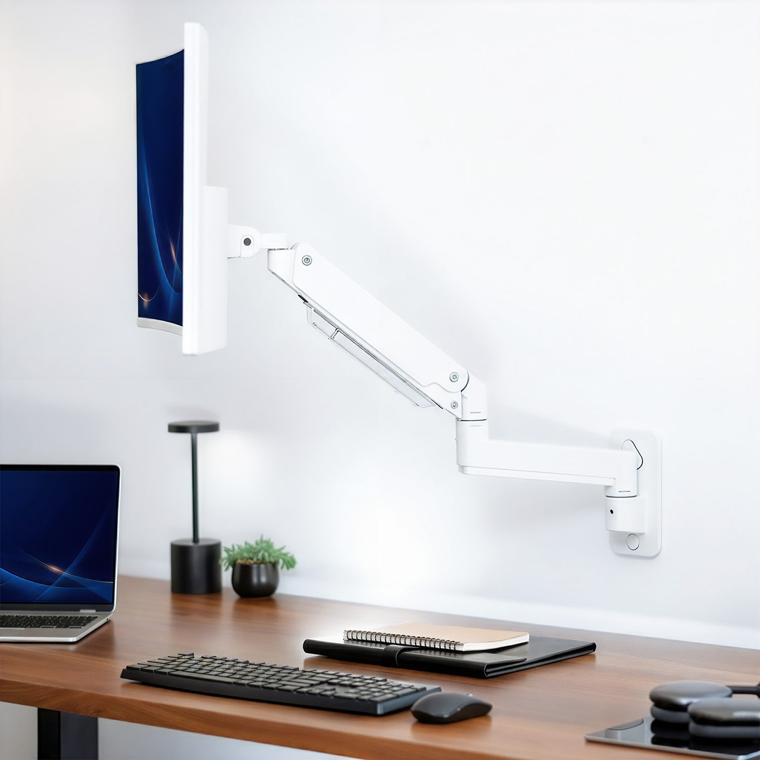 Modern office setup with a desk, computer monitor mounted to wall, keyboard, and lamp on a white background
