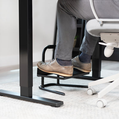 Sit at a taller desk and rolling chair while keeping your legs in a comfortable position.