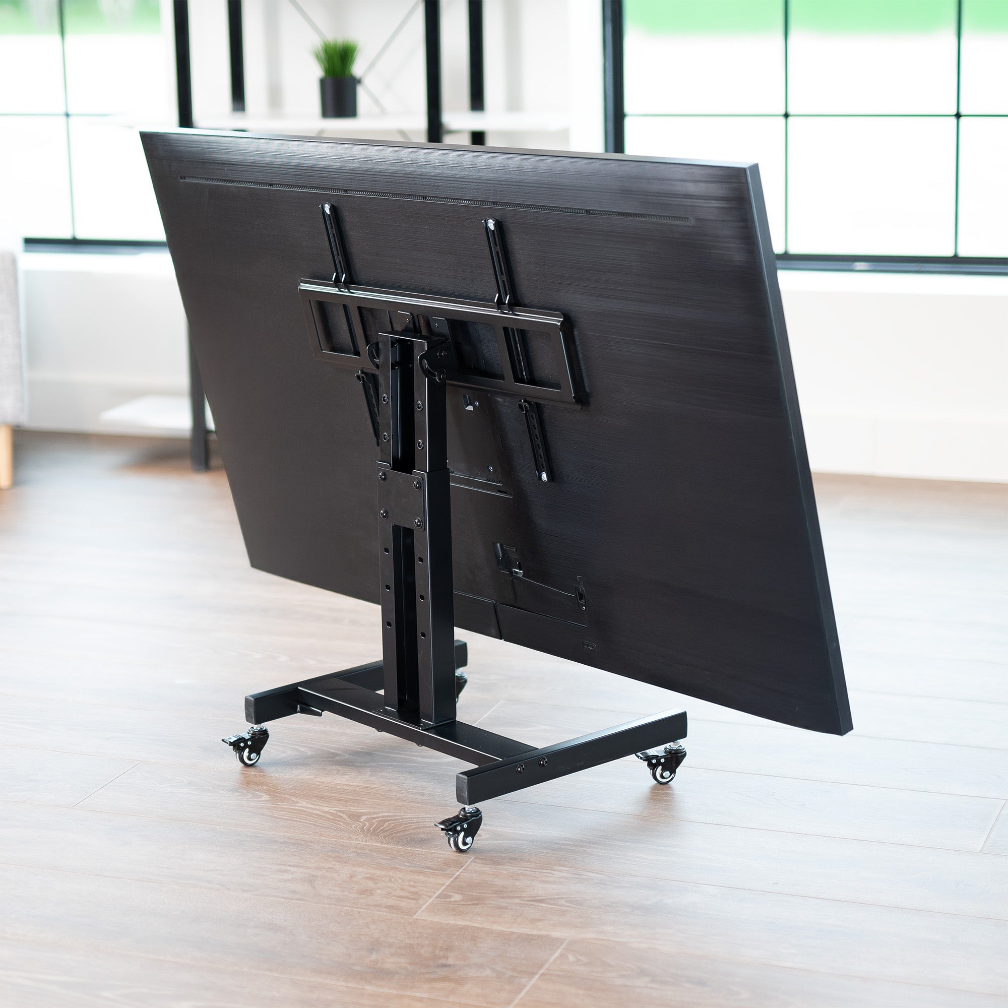 A low height mobile TV cart with a black frame and wheels.