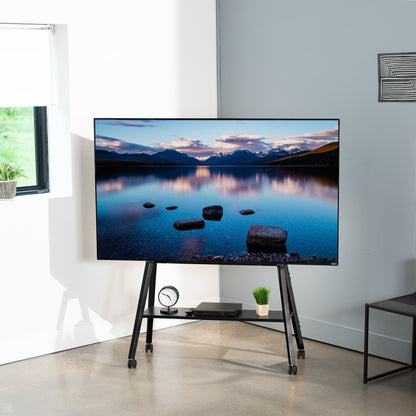 This rolling artistic easel 49 to 75 inch LED LCD screen mobile studio TV display stand is for home theatres, trade shows, schools, and more.