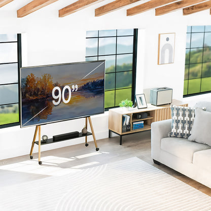 Modern living room with a large TV displaying '90”, white sofa, and wooden floor.