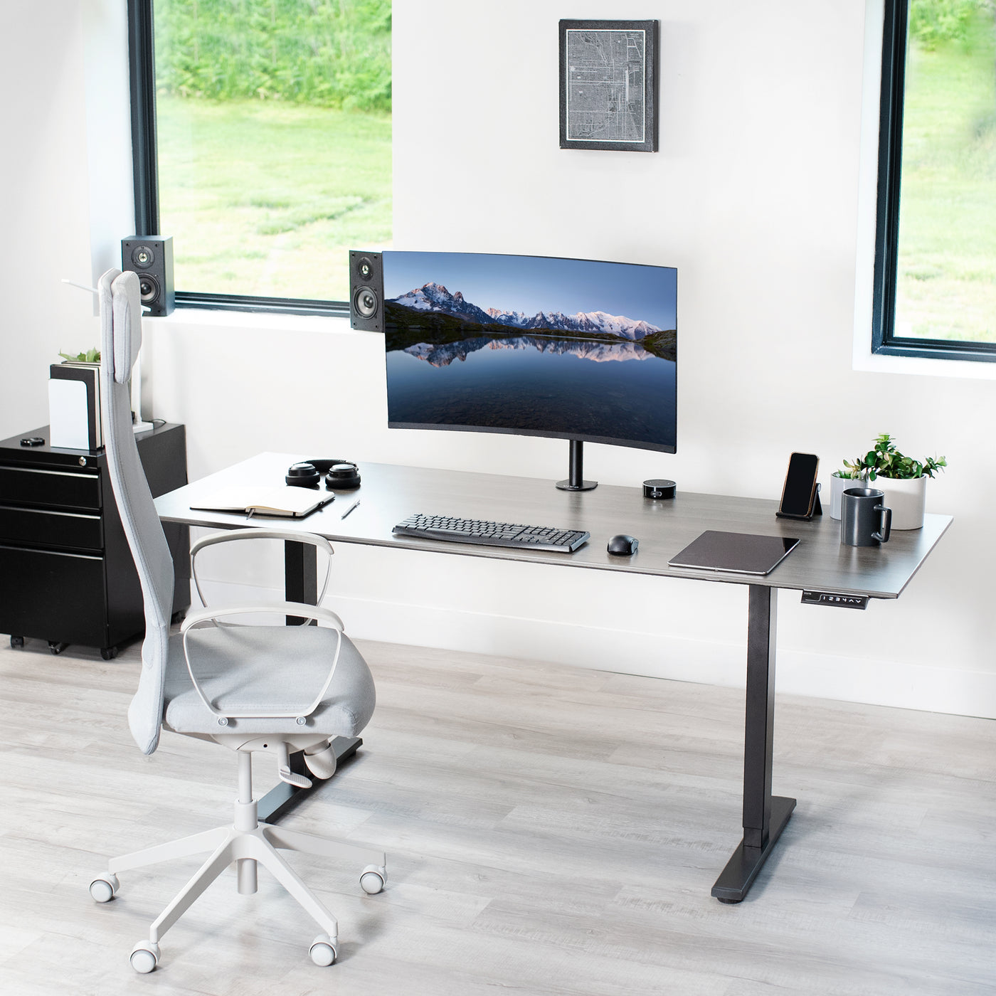 Monitor mount C-clamp desk mount in a modern workspace office setup.