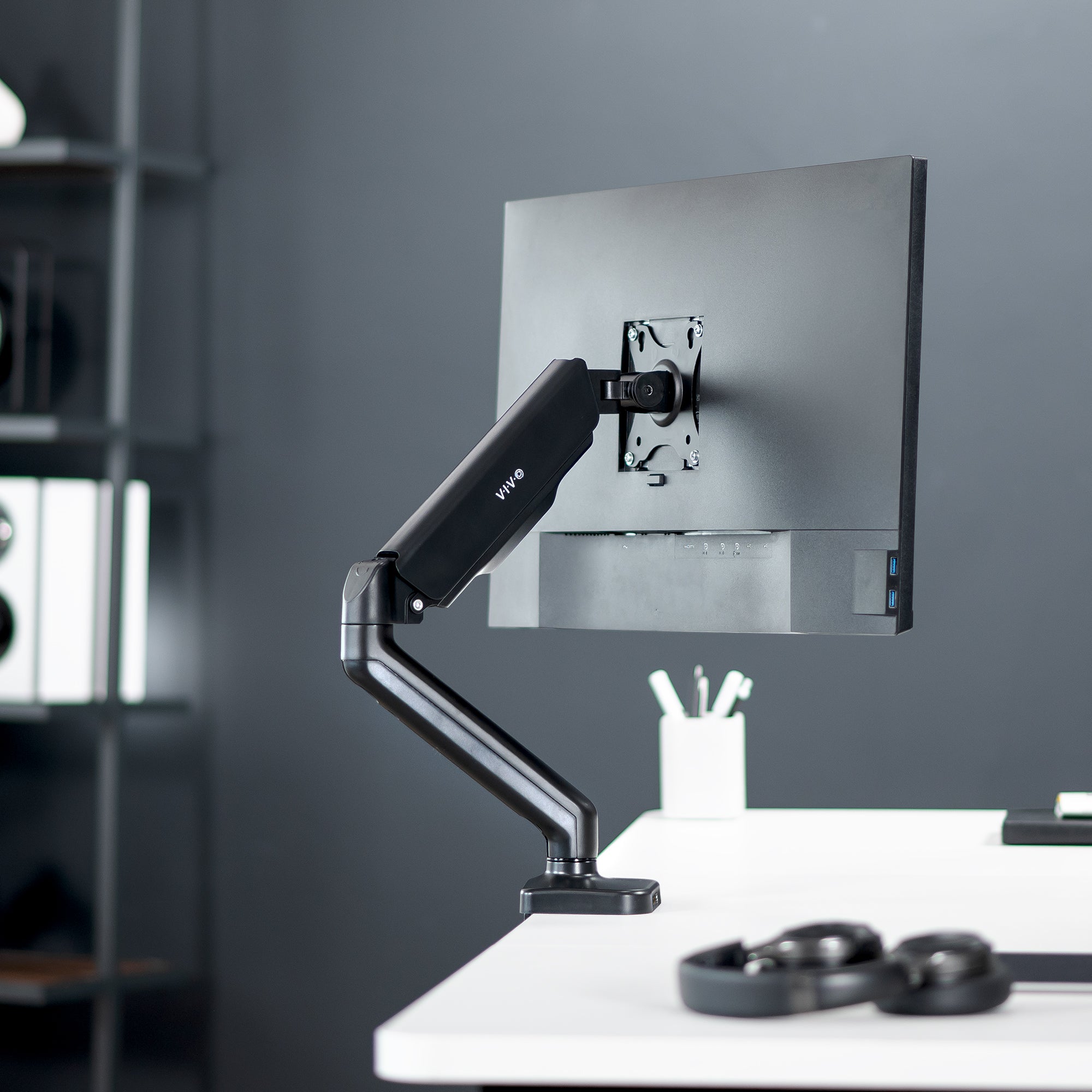 Sturdy clamp-on pneumatic arm single monitor desk mount with USB ports and audio ports, articulation, height adjustment, and cable management.