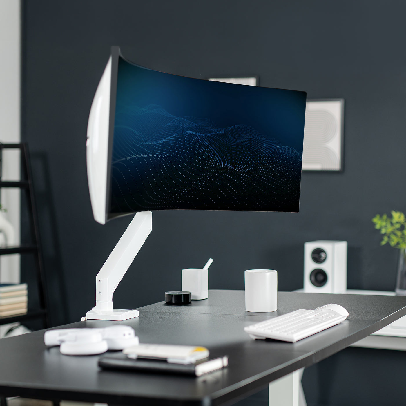 Sturdy arm clamped onto a desk supporting a curved monitor in an aesthetic office.