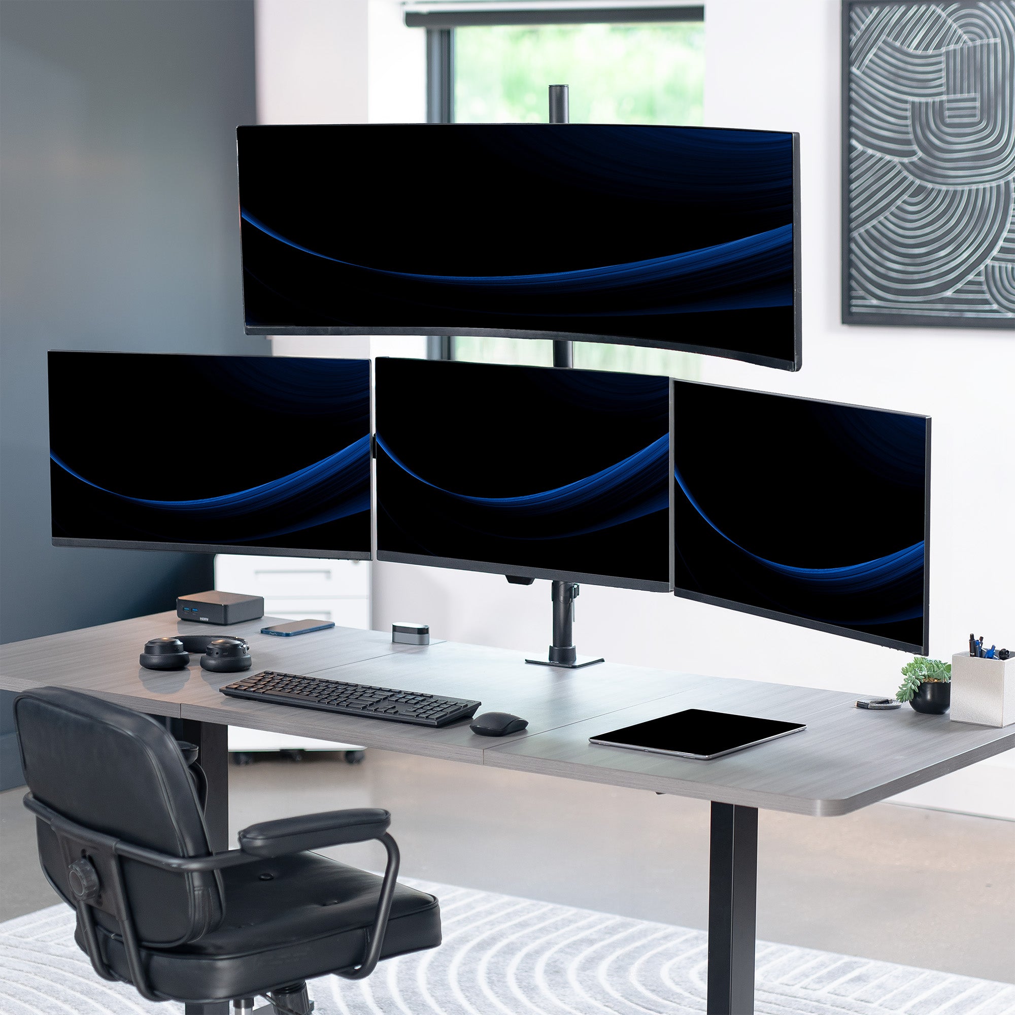 Modern office setup with a desk featuring four computer monitors, a keyboard, and mouse.