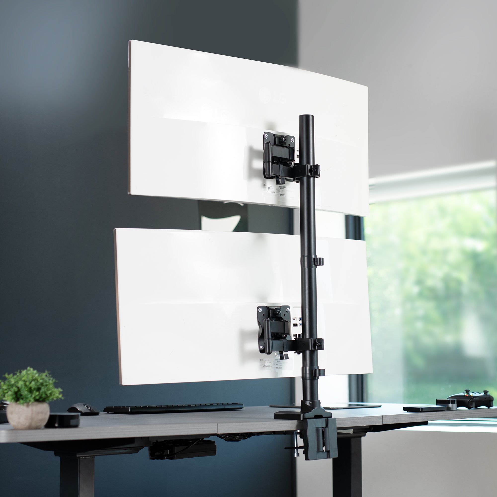 Dual Ultrawide Vertical Monitor Desk Mount in a stacked array elevates 2 large screens to a comfortable viewing angle and saves desk space.