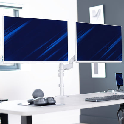 A white dual-monitor desk stand holding two slim computer monitors on a light-colored office desk, with a keyboard, mouse, and other desk accessories in a modern workspace setting.