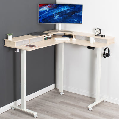 Dual tier height adjustable electric corner desk with storage drawers and wheels.