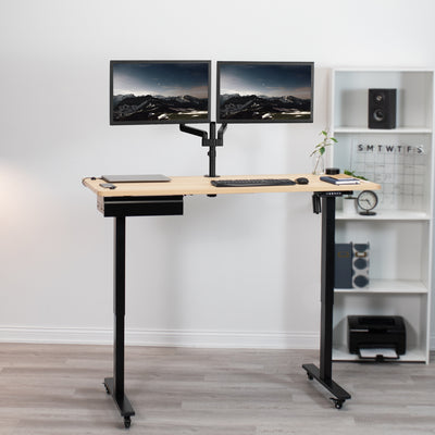 Light wood-colored desk with black frame extended to work while standing.