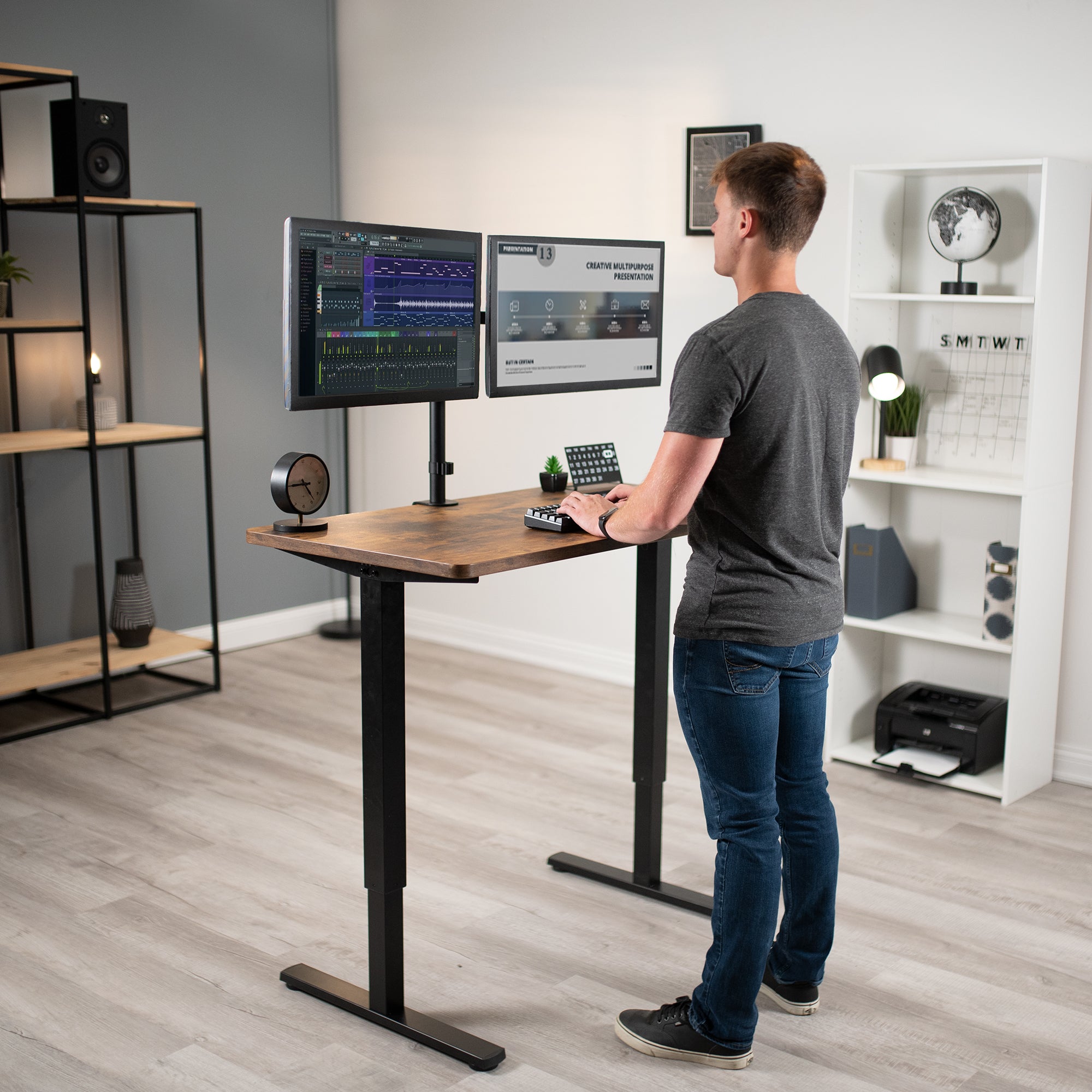 A man working at a manual height adjustable desk with a solid steel desk frame.