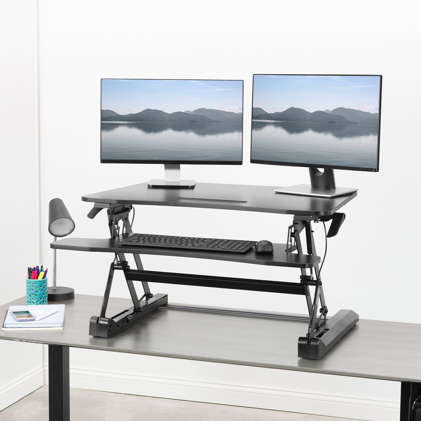 Heavy-duty height adjustable desk converter monitor riser with 2 tiers. 